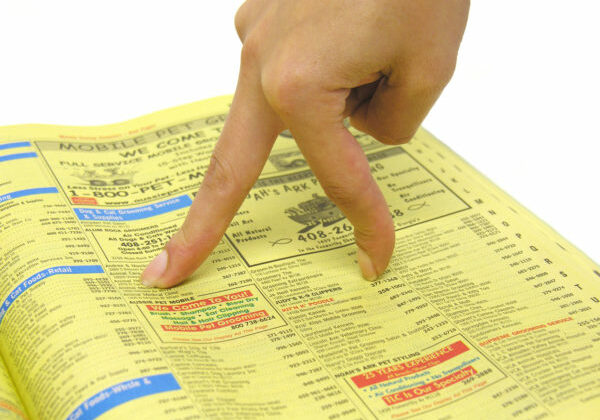 A photo of a woman's fingers walking through the yellow pages
